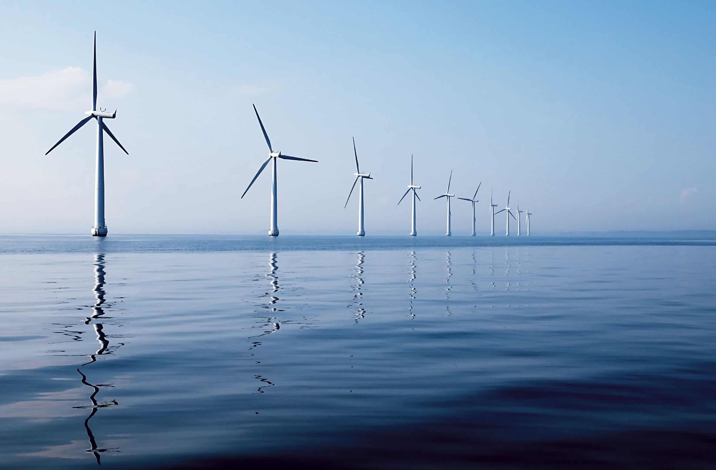 Background image of wind turbines on a calm sea.